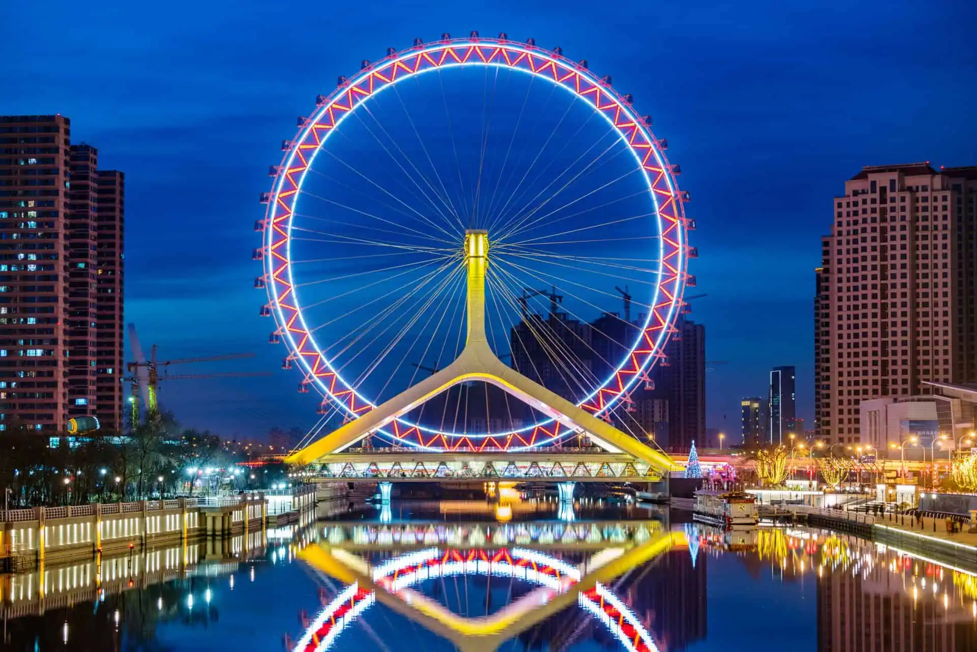 Tianjin Eye Ferris wheel over the river with city skyline