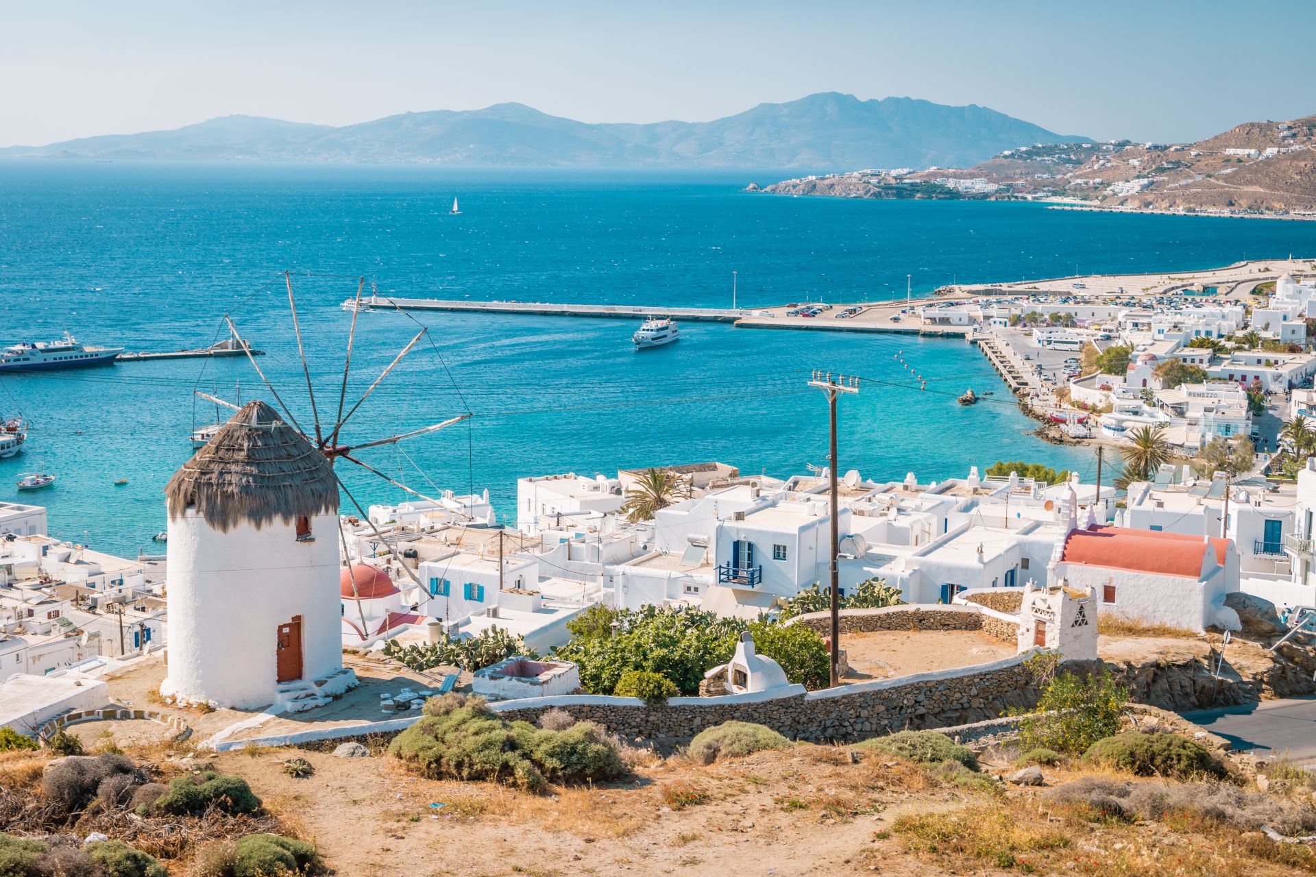 hill with windmill and Mykonos town in Greece