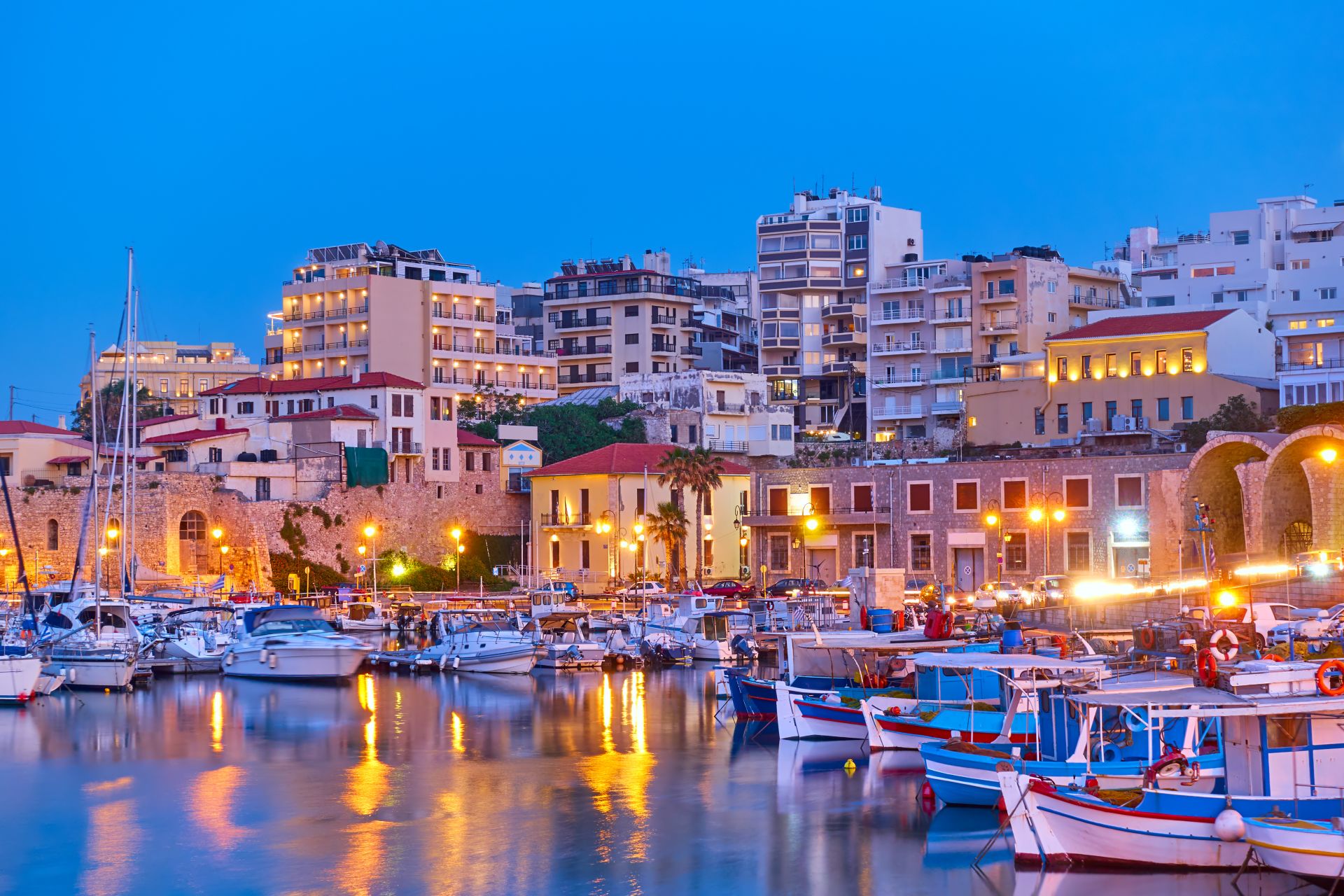 Heraklion city view with port with yachts and fishing boats at sunset