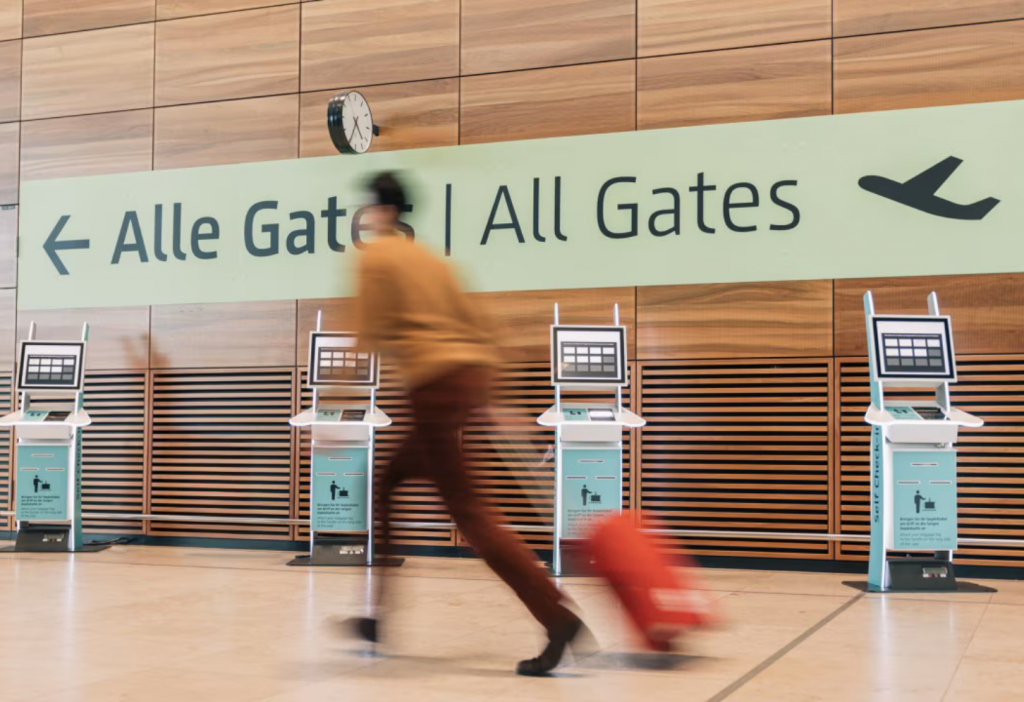 EES Tight Connection Guide — Where Will You Actually Get Processed? 6 Traveler running through airport hall because of EES tight connection guide for U.S. travelers. Learn where biometric checks happen on layovers, MCT changes, and how to avoid missing your next flight EES tight connection