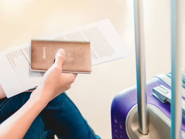 person waiting in the airport with passport in hand